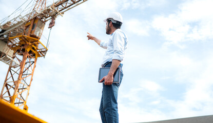 Portrait of engineer with tower crane for lift and move objects on building construction sites