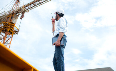 Portrait of engineer with tower crane for lift and move objects on building construction sites