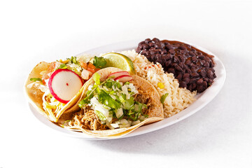 Taco platter with chicken tacos, rice and black beans in a white plate on a white background; copy space