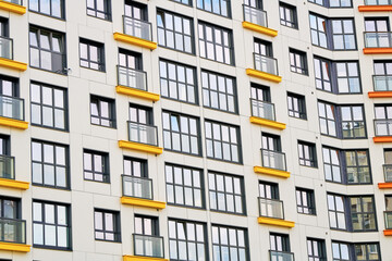 Detail of residential complex, rhythm of the windows, high-rise building closeup. Facade of multi-storey residential building. Residential apartment building exterior. Urban Geometry