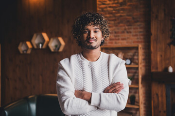 Photo of handsome good mood guy wear white sweatshirt arms folded having rest indoors room home...