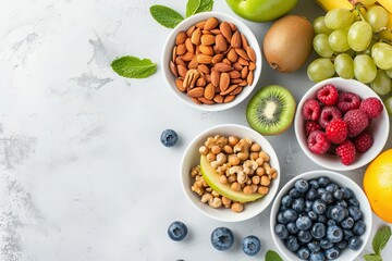 Fresh assortment of healthy fruits and nuts arranged in bowls on a marble background, perfect for a nutritious snack.