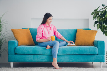 Photo of shiny attractive girl dressed pink shirt drinking coffee eating snacks indoors house apartment room