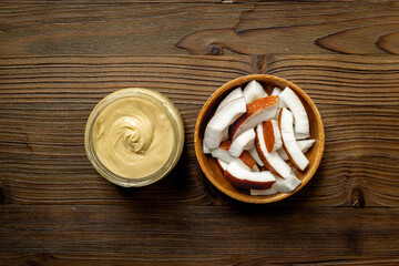 Jar of coconut butter cream with fresh coconuts. Sugar and lactose free vegan food.