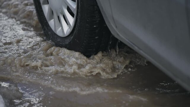 Car Tire Driving Through Puddle of Water on Street, slow motion