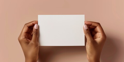 Fototapeta premium blank greeting card mockup with brown complexion manicured hands holding the greeting card horizontally 
