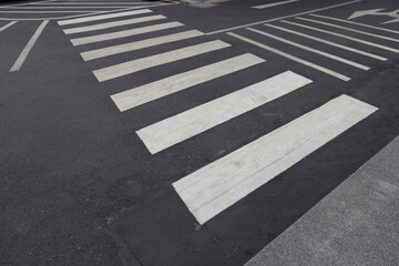 A crosswalk with a white stripe and a black stripe