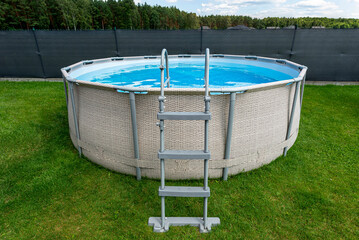 Large expansion pool with a diameter of 3.96 meters, placed in the yard on the grass.