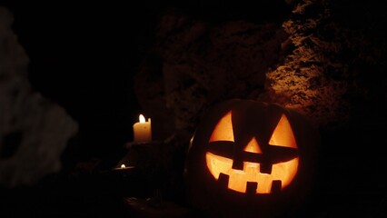 Altar in the Cave Background, Glowing Pumpkin on Halloween Night with Candles on the Rocks.