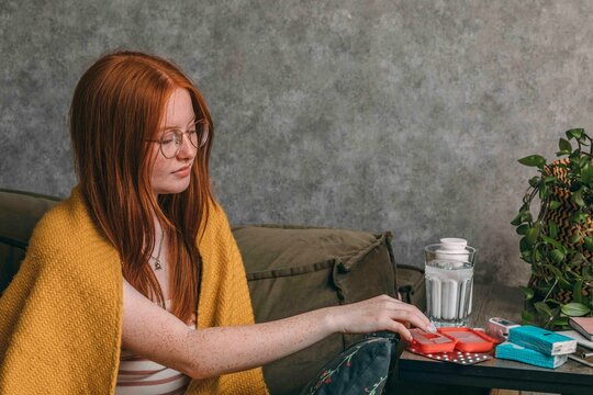 woman arranging her daily supplements, Home Health Monitoring, Ensuring Wellness from Comfort of Home
