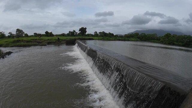 A small dam with tranquil water flowing slowly, creating a calm and serene atmosphere in the surrounding landscape.
