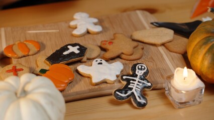 The Creative Process of Preparing for Halloween. A Woman Decorates Gingerbread Cookies in the Shape of People with Icing, Various Shapes with a Holiday Theme.