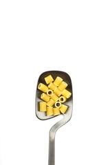 Raw pasta fusilli on wooden spoon on White background. Top view of Italian cuisine ingredient.