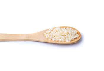 Dried canjica, hominy or white corn in a spoon isolated over white background