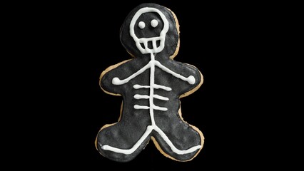 A Black Gingerbread Man Shaped Like a Skeleton Cookie Isolated on Black, Holiday Theme.