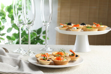 Delicious canapes with shrimps, salmon and caviar on beige textured table