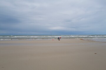 two angler fishing at a sandy beach in the north sea