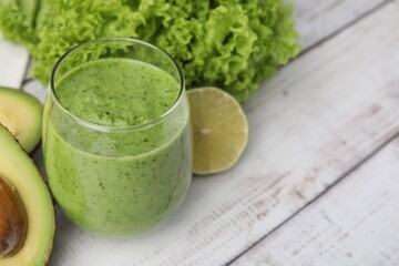 Tasty green smoothie in glass and products on wooden rustic table, closeup. Space for text