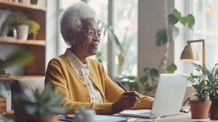 African American senior woman using laptop at Home Office. Concept of elderly connectivity, technology adoption, lifelong learning, remote work