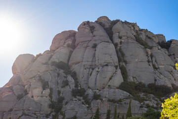 Mountains under the evening sun with rocks of abstract and distinctive shapes are located in the...