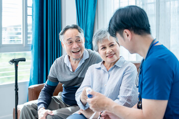 Obraz premium A senior woman with husband giving a health interview to a home visiting nurse in uniform,a young male nurse measuring pulse oximeter and provide advice,concept of elderly health care,home health care