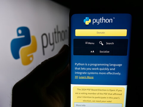 Stuttgart, Germany - 07-17-2024: Person holding mobile phone with website of organisation Python Software Foundation (PSF) in front of logo. Focus on center of phone display.