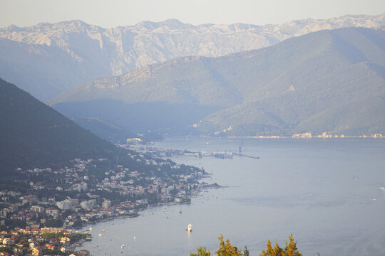 The beauty of the Bay of Kotor from the air: a view of the Adriatic Sea, ships, mountains and settlements in the municipality of Herceg Novi (Bijela, Baosici, Djenovici). Landscapes of Montenegro.
