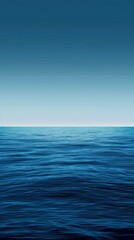 Obraz premium The deep blue ocean meets the pale sky. Creating a serene seascape perfect for daydreaming about paradise.Rippling waves add movement to this tranquil scene