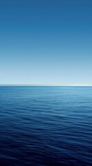 Obraz premium Calm ocean meets clear sky in tranquil seascape, evoking peace and freedom. Gradient of blues with copy space for message. Perfect for backgrounds or travel themes