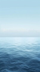 Obraz premium The serene blue of a calm ocean surface blends seamlessly with a pale blue sky, creating a tranquil and minimalist background