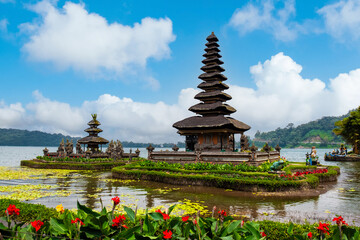 A stunning view of Ulun Danu Beratan Temple in Bali, surrounded by water and lush greenery, under a...