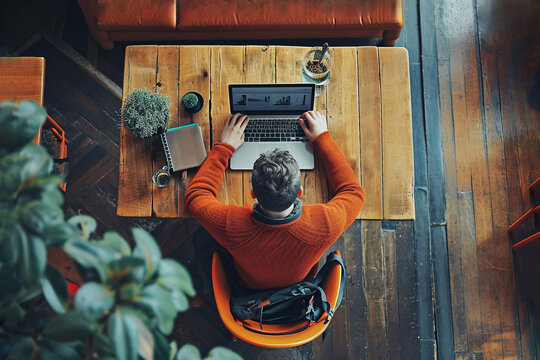 A man works with a laptop in a modern small cafe, top view. AI g