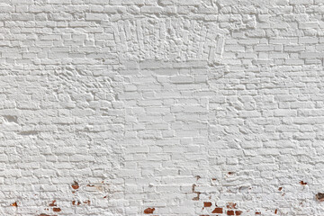 Old red brick wall with walled up window painted in white
