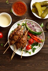 Homemade lula kebab with vegetables on wooden table