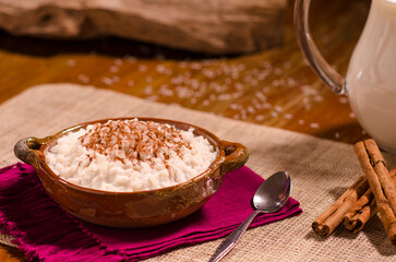 Delicious artisan dessert of sweet rice pudding and cinnamon in a handmade clay container.