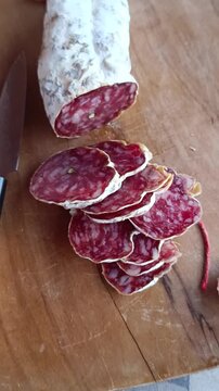 zoom sur un saucisson sec tranch&eacute; sur une planche &agrave; d&eacute;couper