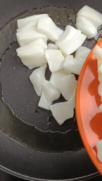 morceaux de calamars cru, en gros plan, en cuisson dans une po&ecirc;le