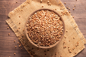 Buckwheat groats on wooden background. Healthy cereal concept.  