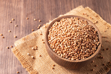 Buckwheat groats on wooden background. Healthy cereal concept.  