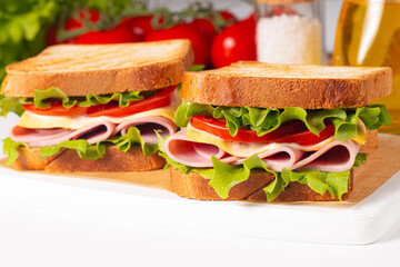 Club sandwich with ham, cheese, tomato and lettuce. 