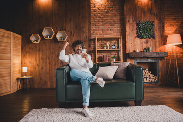 Photo of lucky funny guy wear white sweatshirt winnin game modern device indoors room home house