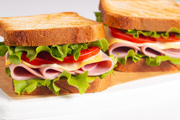 Club sandwich with ham, cheese, tomato and lettuce. 