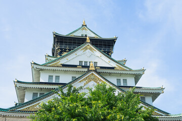 A tall building with a lot of windows and a green roof. Osaka castle. Copy space.