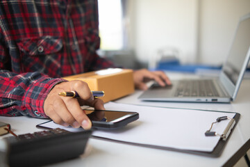 Fototapeta premium Small SME entrepreneurs who operate businesses using their homes as offices and sell products through online applications are checking product stocks to ensure they are sufficient to meet orders.
