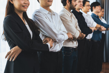 Business team standing, join and link hand together in line symbolize successful business partnership and professional synergy with diverse culture group people cooperation. Prudent