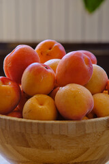 a group of ripe apricots on a wooden plate