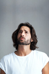 Thinking, question and confused man in studio for remember, decision or thoughtful on gray background. Doubtful, mockup and skeptical male model for daydream, solution or contemplating future