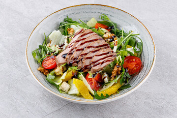 Peking duck on salad with orange on gray background for delivery restaurant menu