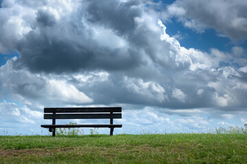 Tranquil hospital setting with a solitary bench and cloudy backdrop