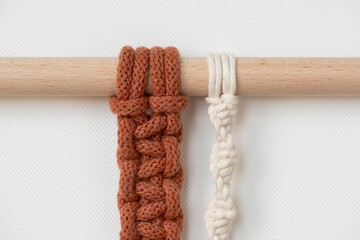 Macrame knots for beginners attached to a wooden stick